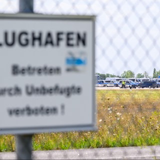 Einsatzkräfte der Polizei sind am Ende der Start-und-Lande-Bahn Nord des Flughafens LeipzigHalle unterwegs.