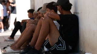 Jugendliche Migranten warten im spanischen Ceuta vor einer Polizeistation.