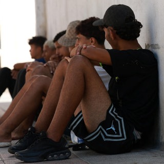 Jugendliche Migranten warten im spanischen Ceuta vor einer Polizeistation.