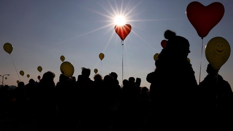 Menschen mit Ballons in der der untergehenden Sonne. Ist das WIR noch möglich? ARD THEMENWOCHE 2022
