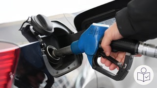 Das ist ein Beispiel·bild: Eine Hand füllt mit einem Tank·stutzen Benzin in ein Auto. Rechts das SWR Logo für Leichte Sprache. 