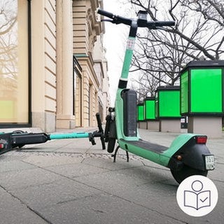 Zwei grüne E-Scooter blockieren einen Gehweg. Der eine liegt auf dem Gehweg. Der andere steht aufrecht. Rechts das SWR Logo für Leichte Sprache.  