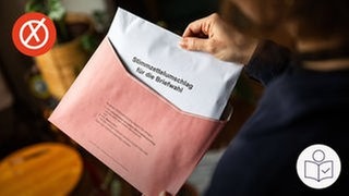 Eine Hand hält einen roten Brief·umschlag. Die andere Hand schiebt einen weißen Umschlag für die Brief·wahl in den roten Umschlag. Rechts das SWR Logo für Leichte Sprache. Links oben ein roter Kreis mit einem weißen Kreuz.