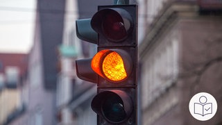 Auf dem Bild ist eine Ampel. Das gelbe Licht an der Ampel leuchtet. Rechts das SWR Logo für Leichte Sprache.