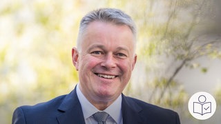 Auf dem Bild sieht man das Gesicht von dem CDU-Politiker Gordon Schnieder. Er wird neuer Minister·präsident vom Bundesland Rheinland-Pfalz. Rechts im Bild das SWR Logo für Leichte Sprache. 