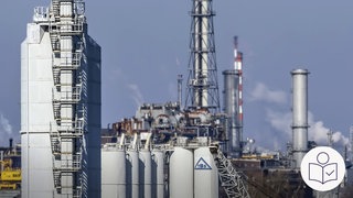 Teile von dem Unternehmen BASF in Ludwigshafen. Man sieht einige Rohre und Behalter. BASF will Arbeits·plätze abbauen. Rechts das SWR Logo für Leichte Sprache.