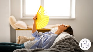 Eine Frau liegt auf einem Sofa. Sie hat einen Fächer in der Hand. Damit fächert sie sich Luft zu. Sie will sich abkühlen, weil es heiß ist. Rechts das SWR Logo für Leichte Sprache. 