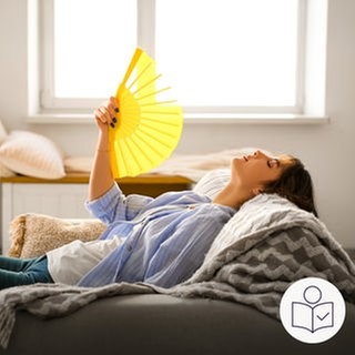 Eine Frau liegt auf einem Sofa. Sie hat einen Fächer in der Hand. Damit fächert sie sich Luft zu. Sie will sich abkühlen, weil es heiß ist. Rechts das SWR Logo für Leichte Sprache. 