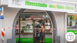 Der Eingang von einem Fitness·studio. In der Tür steht eine Person. Über der Tür ist ein Schild mit grüner Schrift. In dem Fitness·studio in Pflinztal ist ein Teil der Decke eingestürzt. Rechts das SWR Logo für Leichte Sprache.