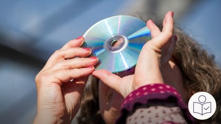 Eine Frau schaut durch eine CD in die Sonne. Rechts unten das SWR-Logo für Leichte Sprache.