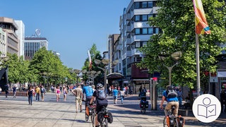Das Bild zeigt eine Fußgänger·zone mit Rad·fahrern und Fuß·gängern. Rechts das SWR Logo für Leichte Sprache. 