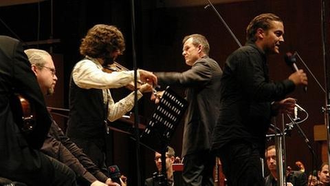 Wieland Hoban, Gjermund Larsen, Francois-Xavier Roth und Lars-Petter Hagen auf der Bühne mit Geiger und Mikrofon