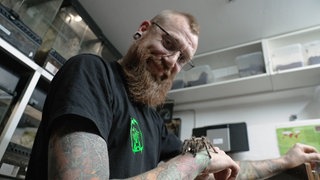 Junger Mann mit Spinne auf dem Arm
