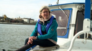 Frau mit blonden Haaren und Brille auf Boot.