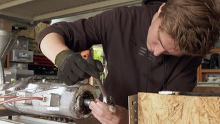 Junger Mann arbeitet an einer Maschine