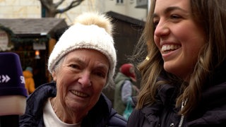 Eine junge und eine alte Frau lachen auf dem Mainzer Weihnachtsmarkt