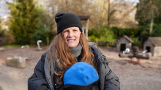Frau steht auf Kinderspielplatz