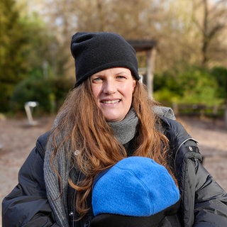 Frau steht auf Kinderspielplatz