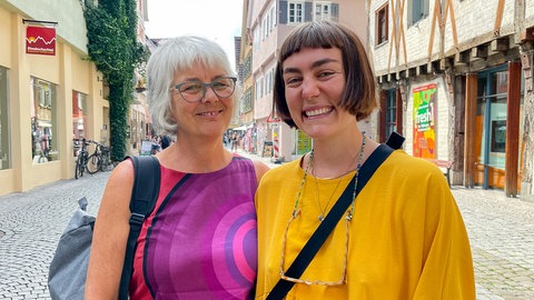 Mutter Ulli und Tochter Clara stehen in der Tübinger Fußgängerzone und lachen in die Kamera.