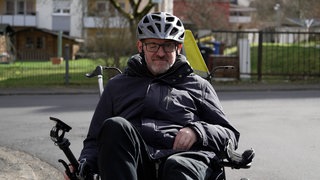 Mittelalter Mann, der mit Helm im Liegefahrrad sitzt