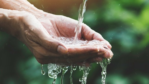 Wasser fließt in eine Hand - Symbolbild zum ARD-Thema #unserWasser: Den Persönlichen Wasserfußabdruck kennen und den Wasserverbrauch pro Person senken, das ist Klimaschutz.