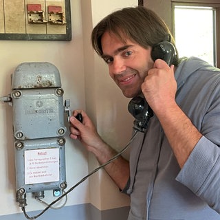 Andreas Kurth am ehemaligen Notfalltelefon des Museumsbahnhofs Üxheim-Ahütte