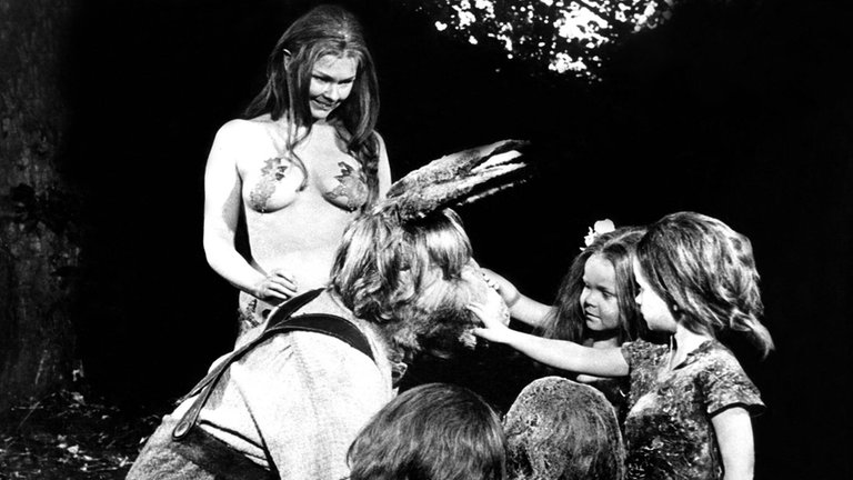Judi Dench (links) als junge, barbusige Titania. Sie führt den eselsköpfigen Zettel zu den Elfenkindern.
