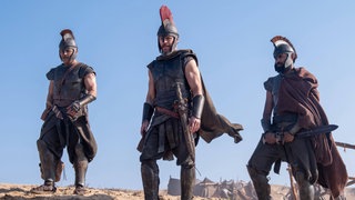 Filmszene aus "Odyssee" von Christopher Nolan: Jimmy Gonzales als Cepheus, Matt Damon als Odysseus und Himesh Patel als Eurylochus