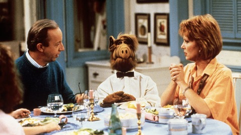 Die Serienfamilie Tanner mit ALF beim Dinner.