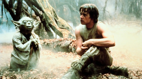 Mark Hamill als Luke Skywalker neben der Figur Yoda in "Das Imperium schlägt zurück" (1977)