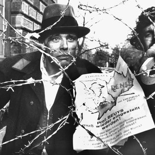 Der am 11.Oktober 1972 fristlos entlassene Professor an der Düsseldorfer Kunstakademie, Joseph Beuys (l), schaut am 23.11.1972 durch eine Stacheldrahtbarriere, die von Kunststudenten in Düsseldorf aus Protest gegen seine Entlassung errichtet worden ist.
