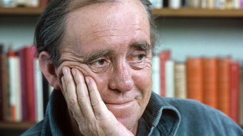Mann vor Bücherregal