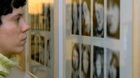 Eine Frau betrachtet Fotografien des Malers Gerhard Richter in der Schau „Zur Vorstellung des Terrors: Die RAF“ 2005 in der Berliner Galerie.
