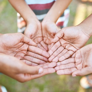 Kinderhände die auf eine Spende für wohltätige Zwecke hoffen