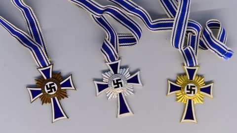 Hitlers  „Mutterkreuz“ in Bronze, Silber und Gold. 