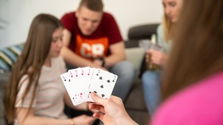 Junge Erwachsene spielen Karten