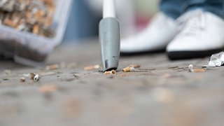 Zigarettenkippen liegen auf dem Boden. Mit einem Akku-Staubsauger werden sie eingesaugt. Zigaretten, Taschentücher und Kaffebecher: So schlimm sind diese 3 Müll Arten für die Umwelt. Bei den SWR1 Dreck weg-Wochen stellt SWR1 eure Müllsammel-Projekte vor.