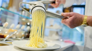 Eidiele in Deutschland: Vanilleeis wird durch eine Spätzlepresse gedrückt