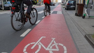 Zwei Radfahrer auf Radweg in der Stadt.