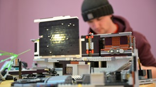 Junger Mann baut mit LEGO