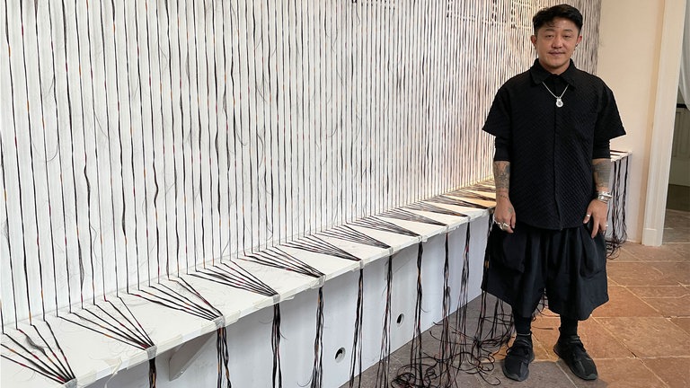 Der philippinsche Künstler Rocky Cajigan vor seiner Installation „Here lies“