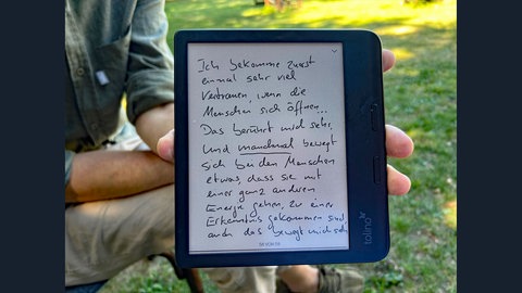 Daniel Beerstecher zeigt ein Tablet mit einem Text - die Antwort auf eine Frage der Autorin