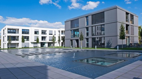 Moderne Mehrfamilienhäuser, im Vordergrund ein flaches Wasserbecken