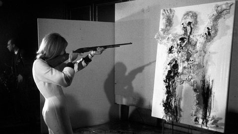 Das Bild zeigt Niki de Saint Phalle mit dem Gewehr im Anschlag