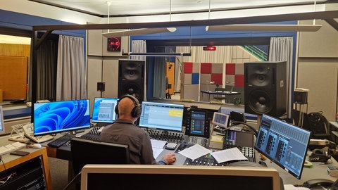 Regisseur Ulrich Lampen vor seinem Pult im Tonstudio. Er überwacht das Einsprechen und gibt Verbesserungswünsche an.