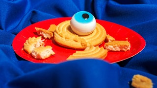 Gruseliges Spielzeugauge auf einem süßen Gebäckstück.