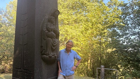Norbert Scheuer am Gedenkkreuz auf dem Kalvarienberg in Prüm, das an die Katastrophe von 1949 erinnert.