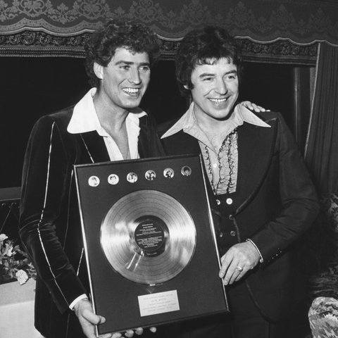 Musikproduzent Jack White (links) und Schlagersänger Tony Marshall feiern 1976 das Erreichen der 100-Millionen-Schallplatten-Verkaufsmarke aller Jack White-Produktionen.