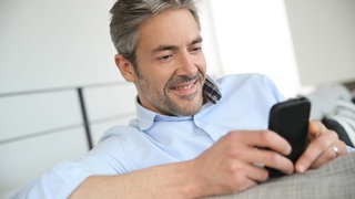 Mann schaut aufs Smartphone