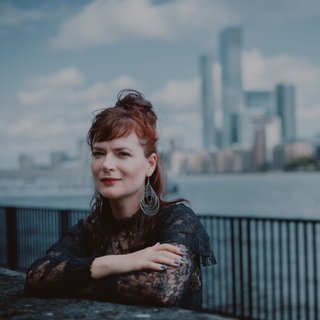 Elina Duni schaut vor einer Skyline in die Kamera